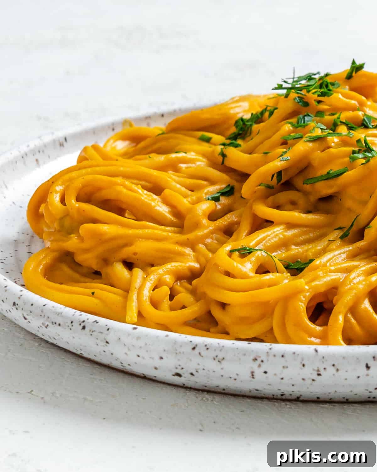 Velvety Sweet Potato Spaghetti 15 Completed Sweet Potato Pasta Sauce with Spaghetti beautifully plated against a white surface, ready to be enjoyed