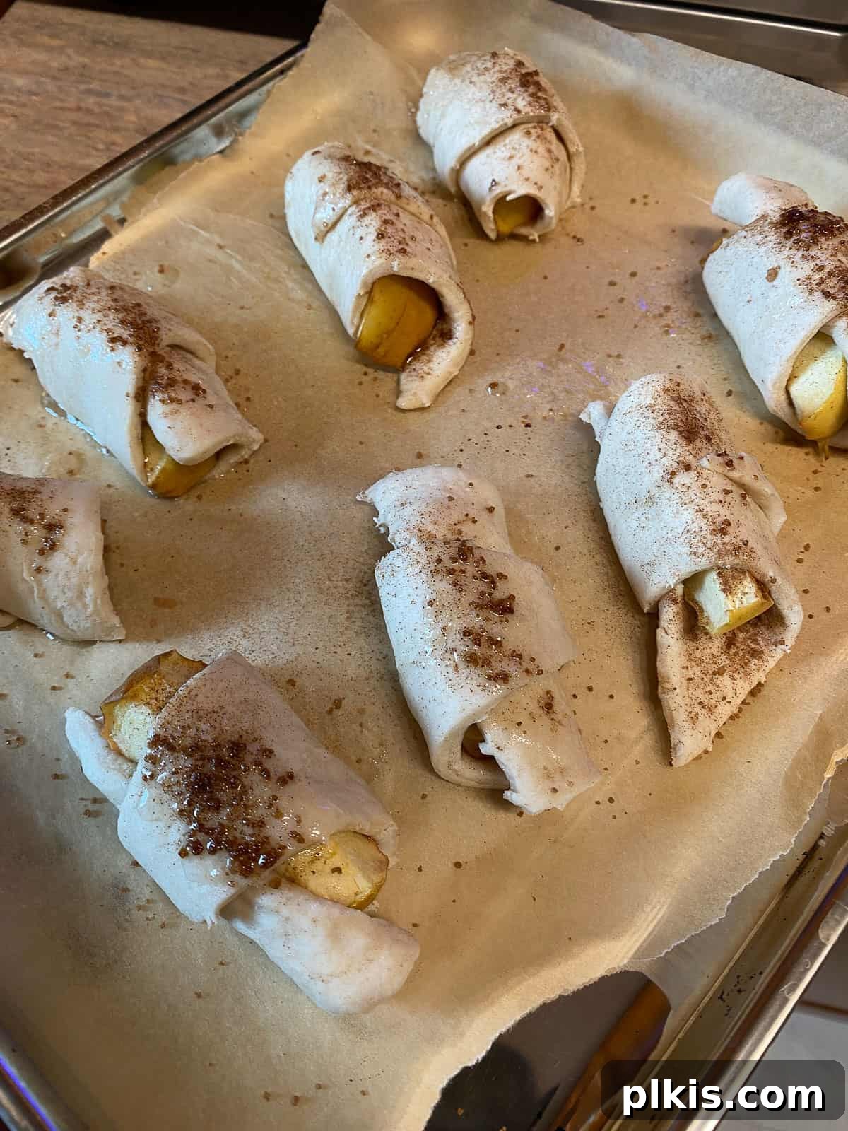 Golden Apple Cinnamon Crescents 13 Assembled vegan apple crescent rolls arranged on a baking tray, before baking.