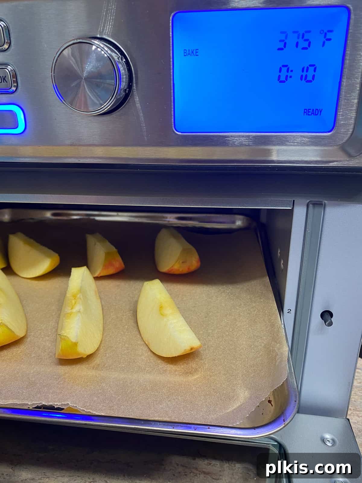 Golden Apple Cinnamon Crescents 5 A baking sheet with sliced apples being placed into an oven.