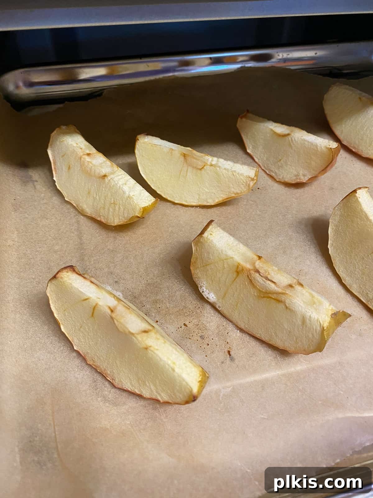 Golden Apple Cinnamon Crescents 6 Softened, pre-baked apple slices on a baking sheet after being removed from the oven.