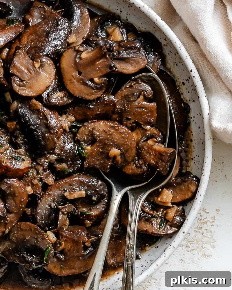 Sizzling Garlic Thyme Mushrooms 12 completed Sauteed Mushrooms with Garlic and Thyme on a white surface, ready to serve