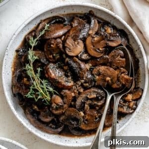 completed Sauteed Mushrooms with Garlic and Thyme on a white surface