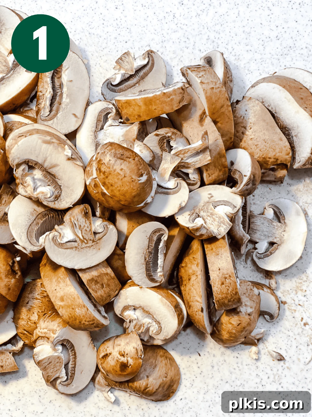 Sizzling Garlic Thyme Mushrooms 4 process shot of slicing mushrooms on a white surface