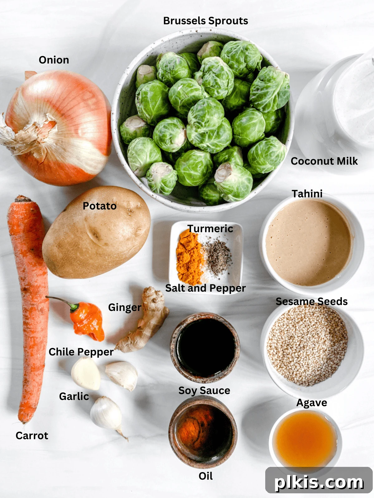Aromatic Brussels Sprouts Curry 3 Various ingredients for Brussels Sprouts Curry, including fresh vegetables, spices, and coconut milk, neatly arranged on a white surface.