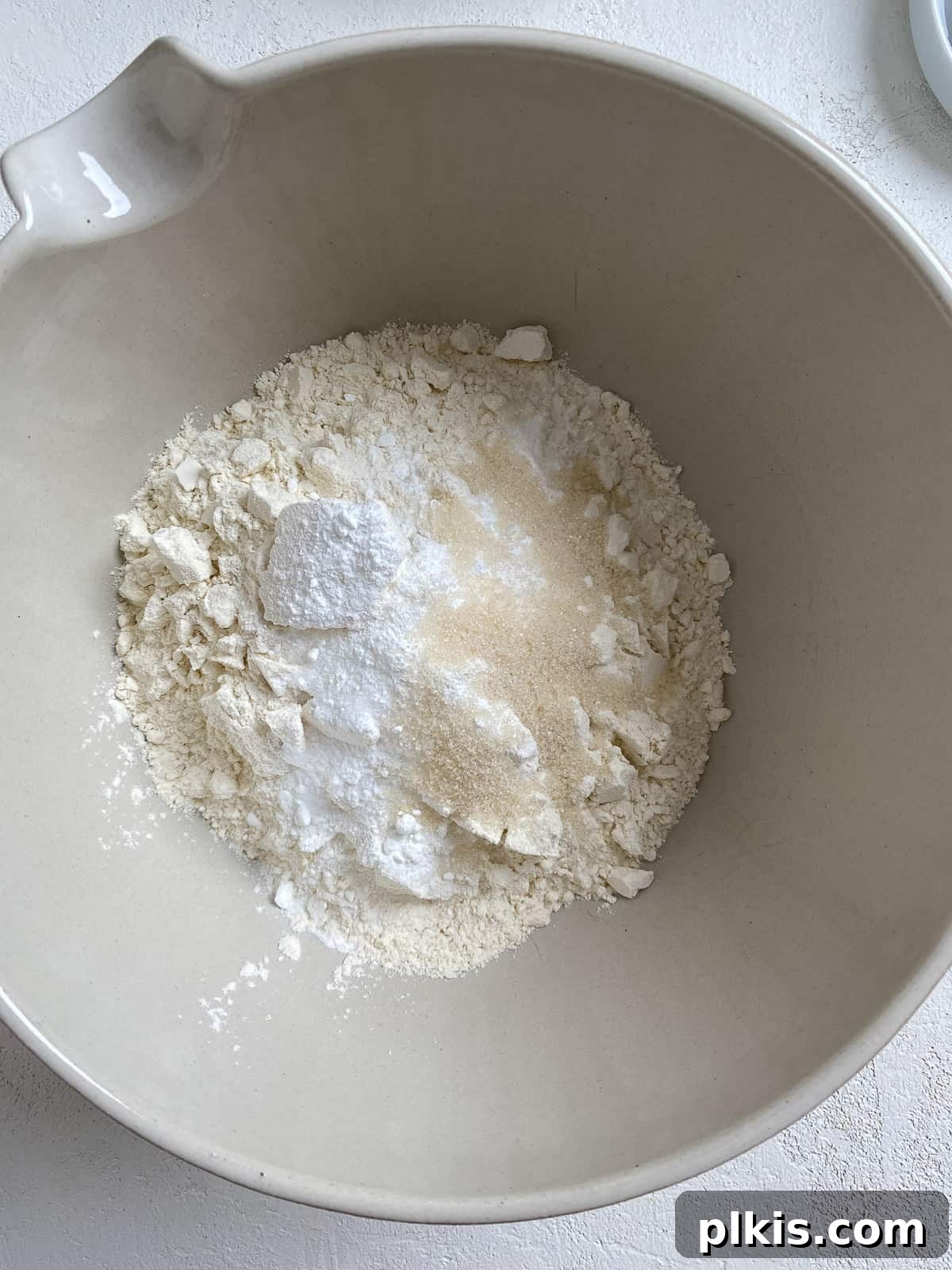 Golden Sage Butternut Biscuits 5 Dry ingredients including flour, baking powder, baking soda, sugar, and salt being mixed together in a bowl.