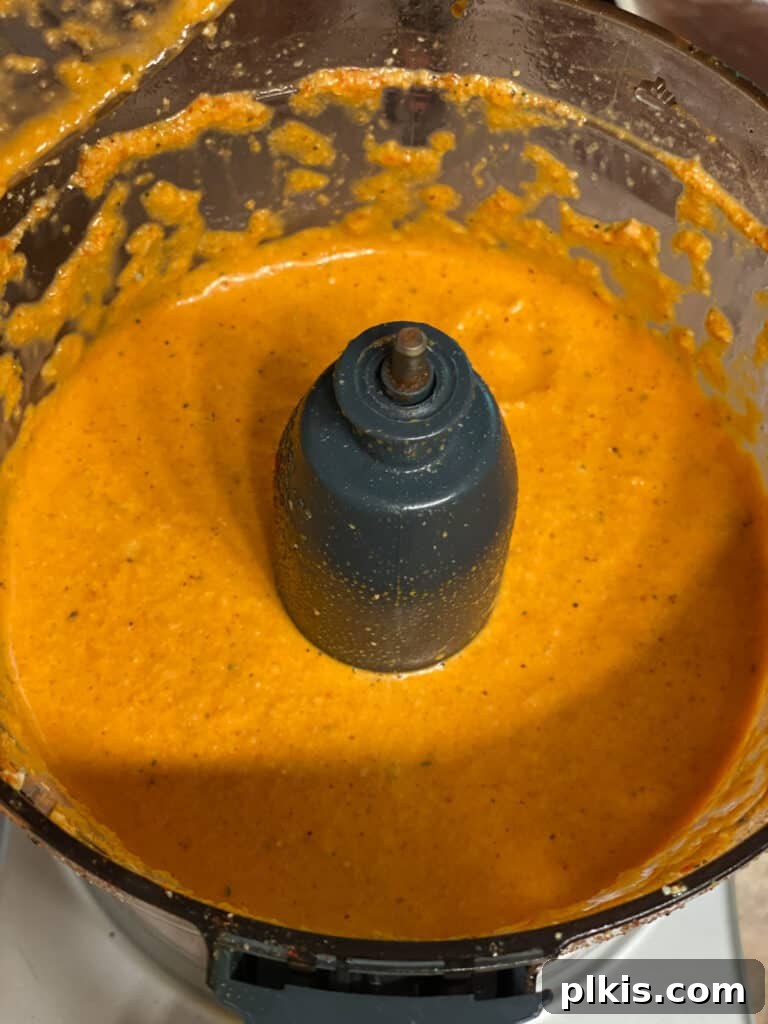 Process shot: The smooth and creamy red pepper cashew sauce after blending in a food processor, ready for the casserole.