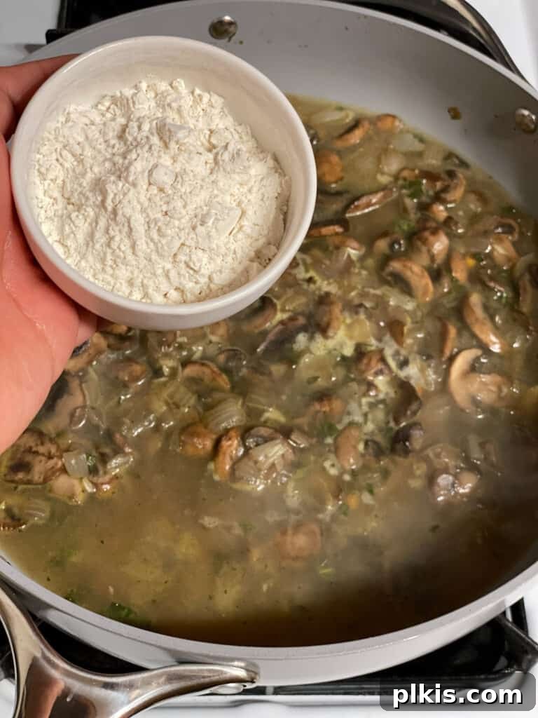 Flour being sprinkled into the gravy mixture in the pan, to thicken it to the desired consistency.