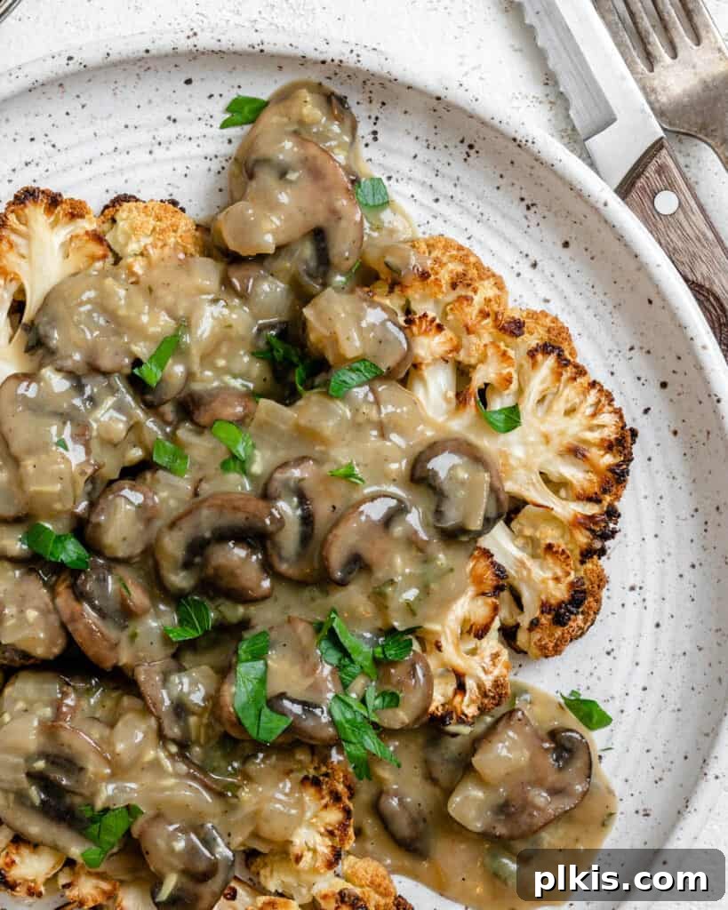 Close-up of a perfectly cooked cauliflower steak, garnished and ready to eat, highlighting its crispy texture and tender interior.