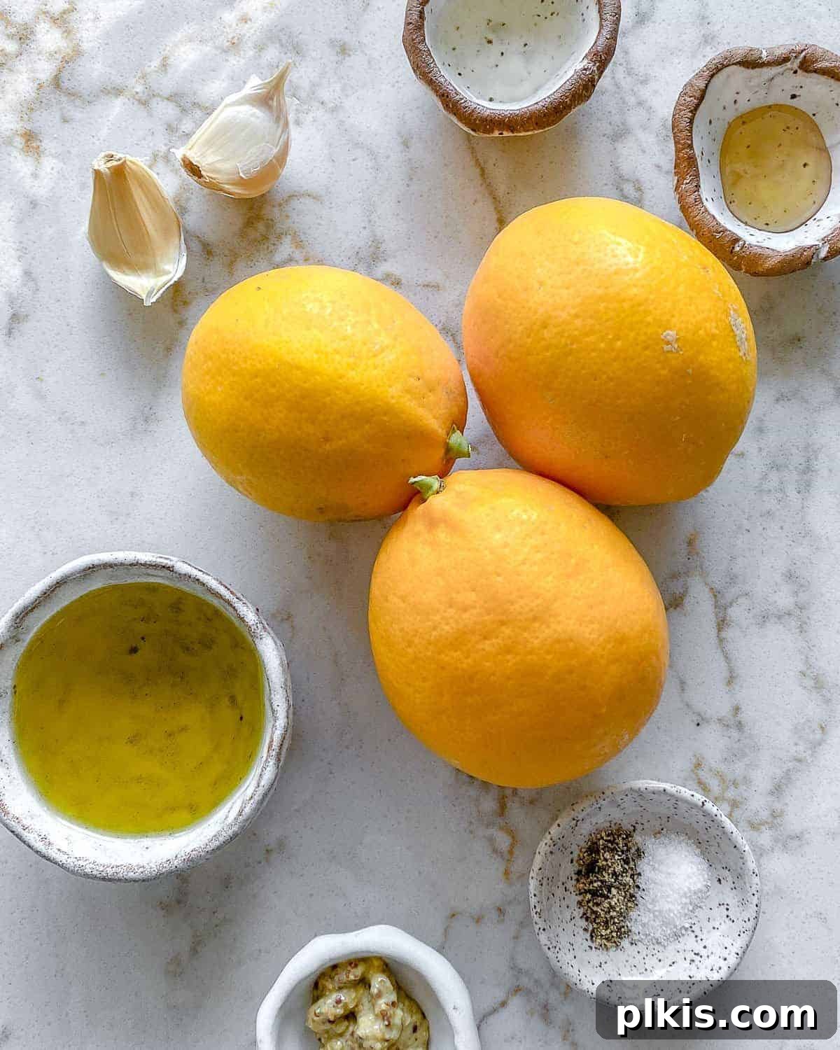 ingredients for lemon dressing against a white background