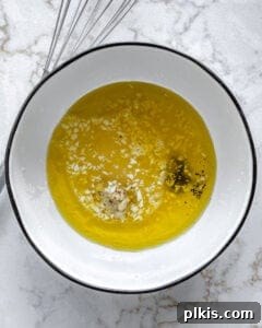 lemon dressing ingredients added to white bowl against white background