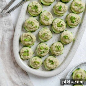 completed Easy Cucumber Bites with Sunflower Chive Cream Cheese plated on a dish against a light background