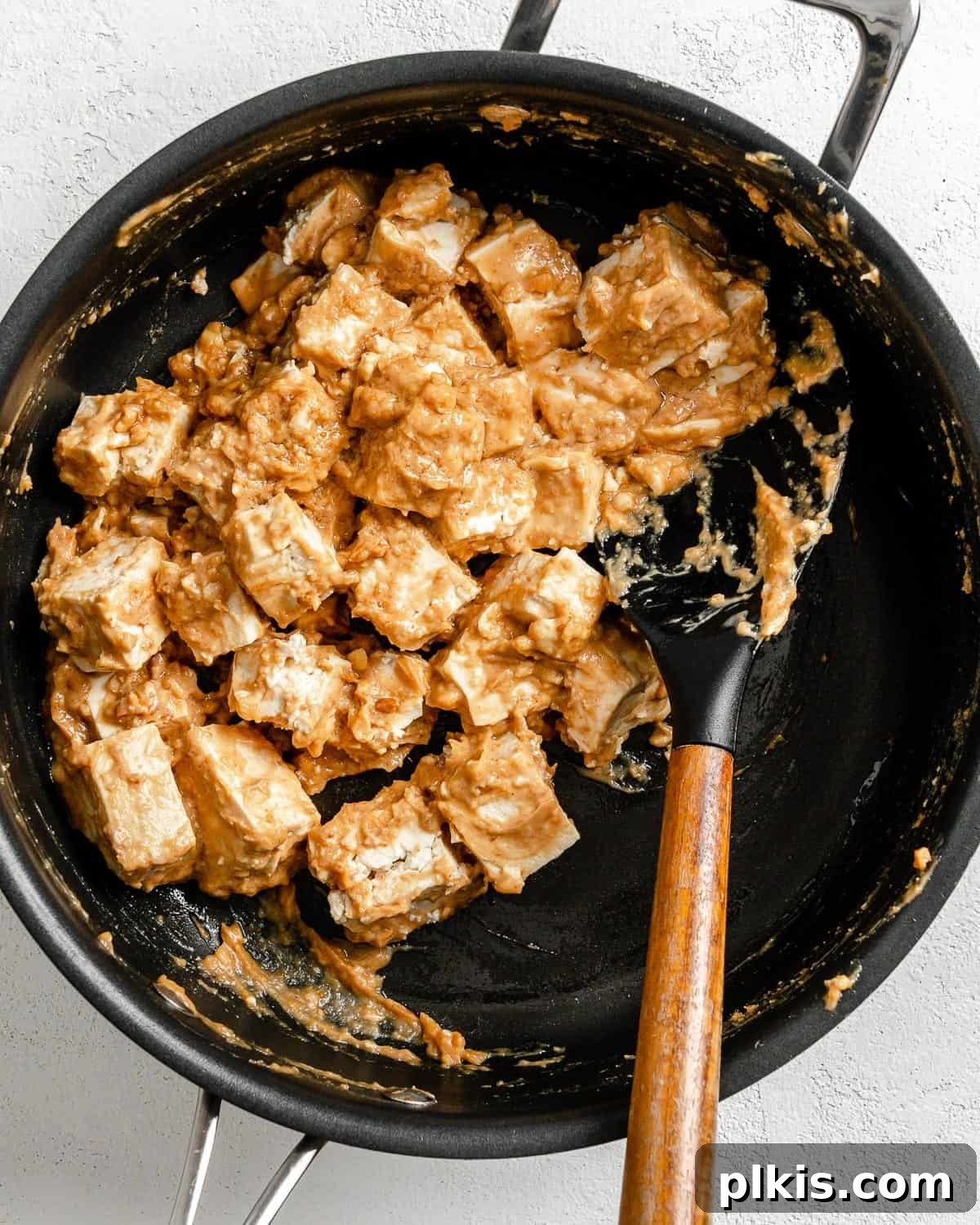Irresistible Vegan Thai Pizza 6 process shot of mixing tofu with sauce in black pan