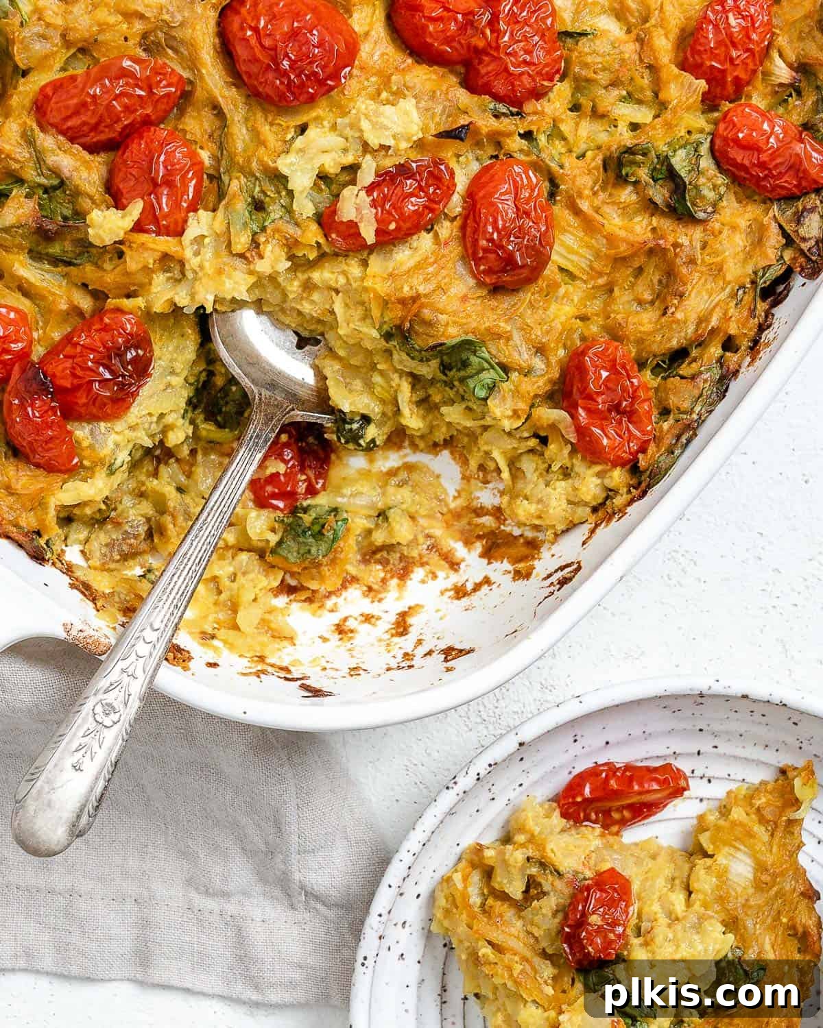 Completed Vegan Potato Frittata [Breakfast Casserole] in a baking tray against a light background, showcasing its golden-brown top and colorful fillings.