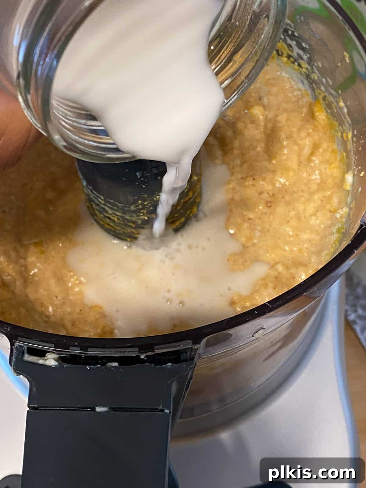 Process shot of adding cornstarch mixture to a blender, essential for helping the vegan frittata set during baking.