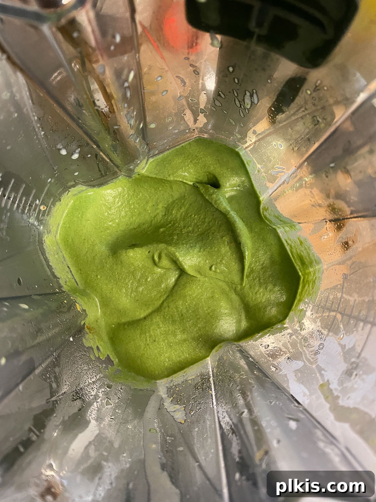 Dreamy Vegan Spinach Dip 11 A high-speed blender contains the perfectly smooth and creamy texture of the freshly blended vegan spinach dip, ready to be transferred to a serving bowl.
