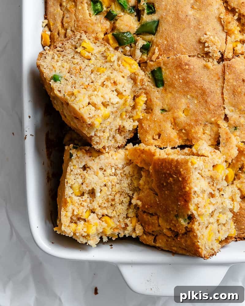 Zesty Jalapeño Cornbread 11 close up on slices of baked jalapeno cornbread in a white baking dish.