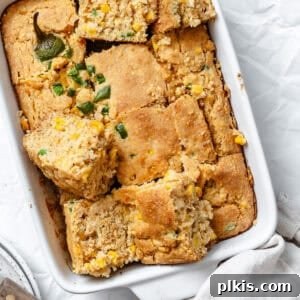 Zesty Jalapeño Cornbread 13 slices of baked jalapeno cornbread in a white baking dish.