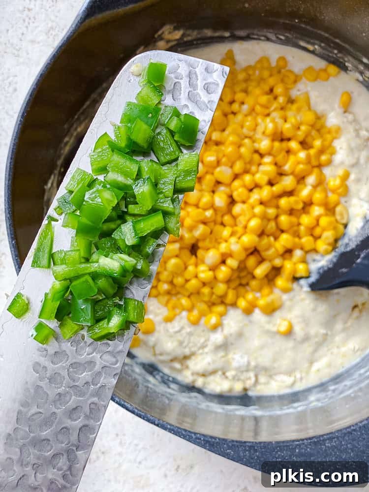 Zesty Jalapeño Cornbread 9 holding diced jalapenos over cornbread batter in a bowl.