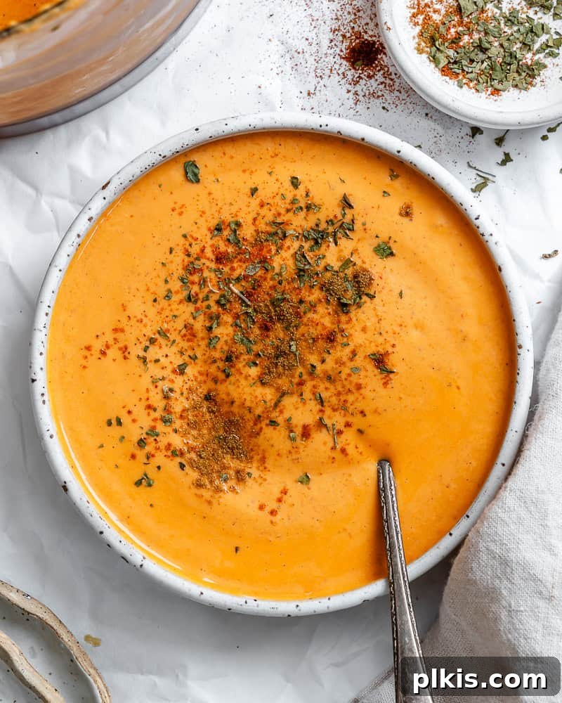 Smoky Roasted Red Pepper Hummus 2 completed Roasted Red Pepper Hummus in a bowl, garnished with a drizzle of olive oil and a sprinkle of paprika