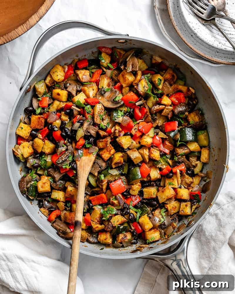 Close-up of a vibrant Breakfast Potato Hash [Roasted + Skillet] served in a cast iron pan, showing crispy potatoes and colorful vegetables