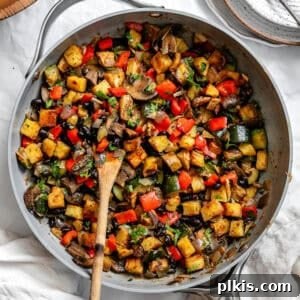 Completed Breakfast Potato Hash [Roasted + Skillet] in pan, with a serving spoon, ready to be enjoyed