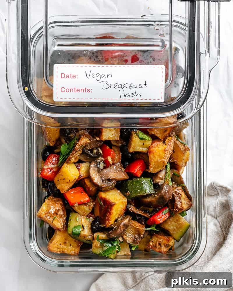 A portion of the completed Breakfast Potato Hash [Roasted + Skillet] stored neatly in a clear glass meal prep container, ready for the fridge