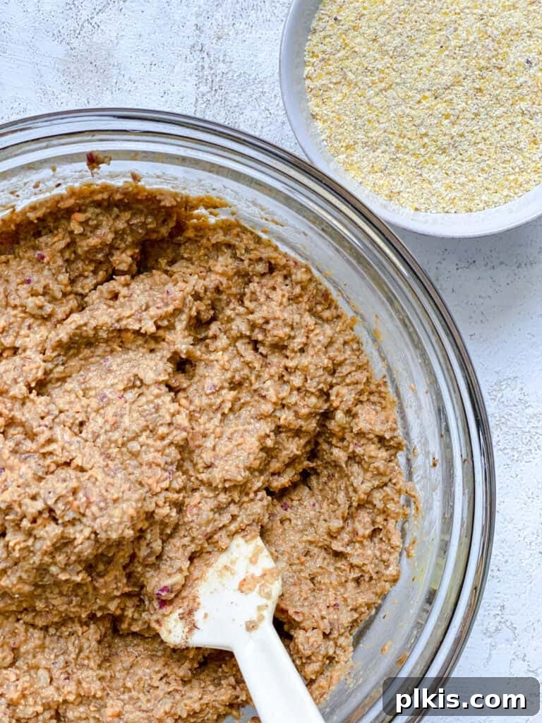 Ultimate Vegan Lentil Burgers 14 Process shot of mixing cornmeal into the burger mixture in a bowl.