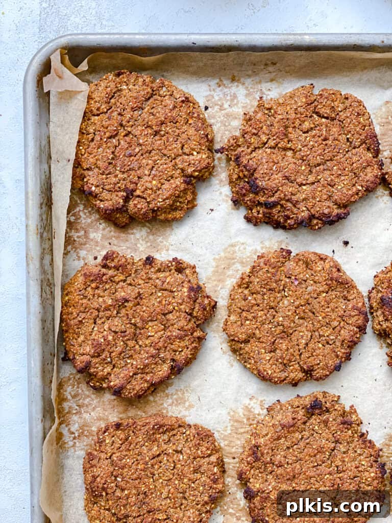 Ultimate Vegan Lentil Burgers 17 Post-baked lentil burgers on a baking sheet, golden and crispy.
