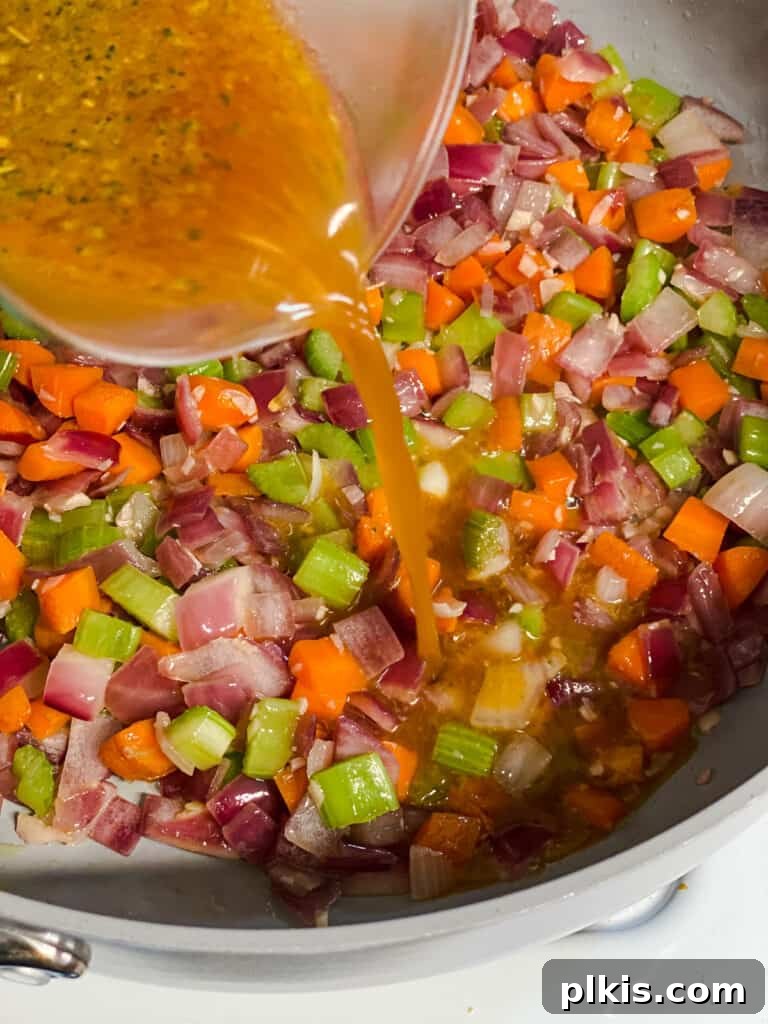 process shot of adding broth to pan