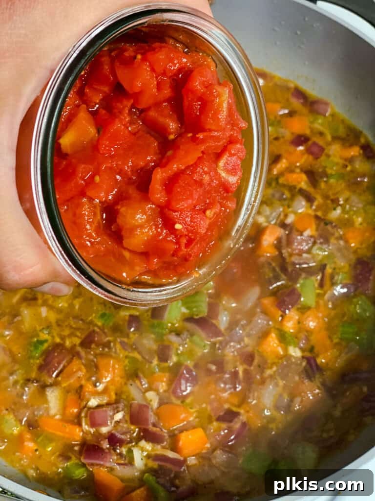 process shot of adding tomatoes to pan