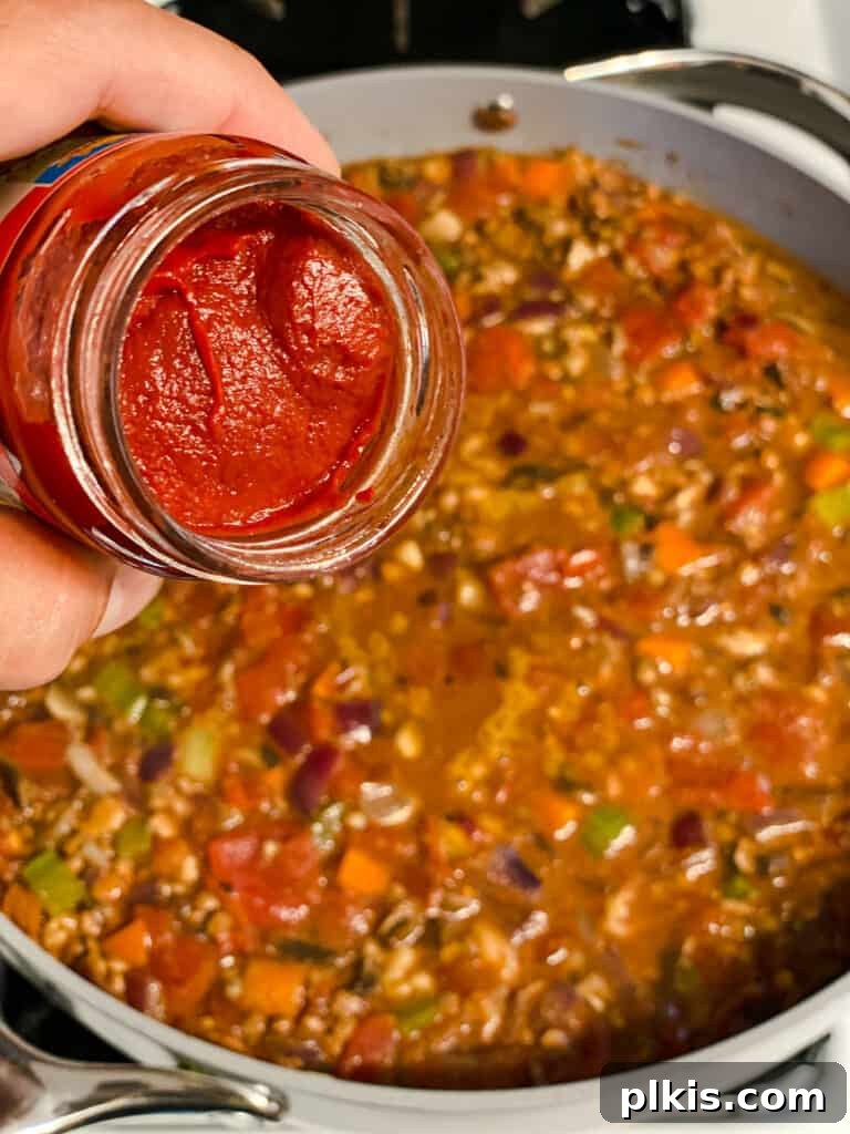 process shot of adding tomato paste to pan