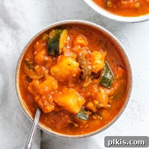 Completed Tomato Soup with Potatoes on a white surface, garnished and ready to serve.