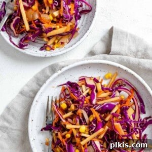 Garden Fresh Vegan Coleslaw with Apple, Carrots, and Corn 10 completed vegan slaw on two white plates against a light background