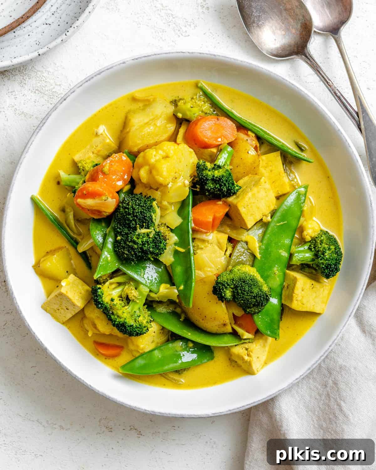 completed Easy Tofu Vegetable Coconut Curry in a bowl against a white background