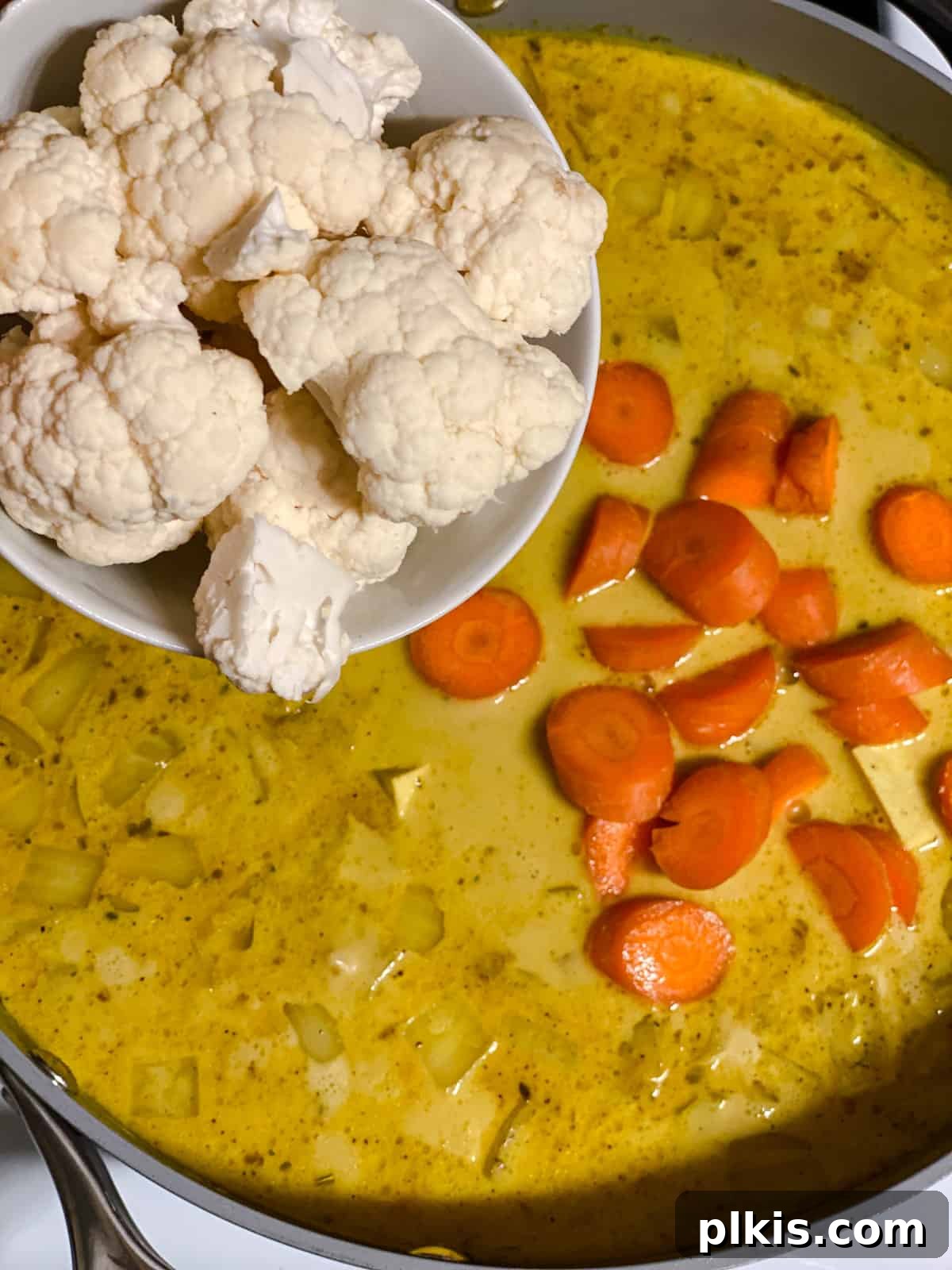 process shot of adding cauliflower to pan