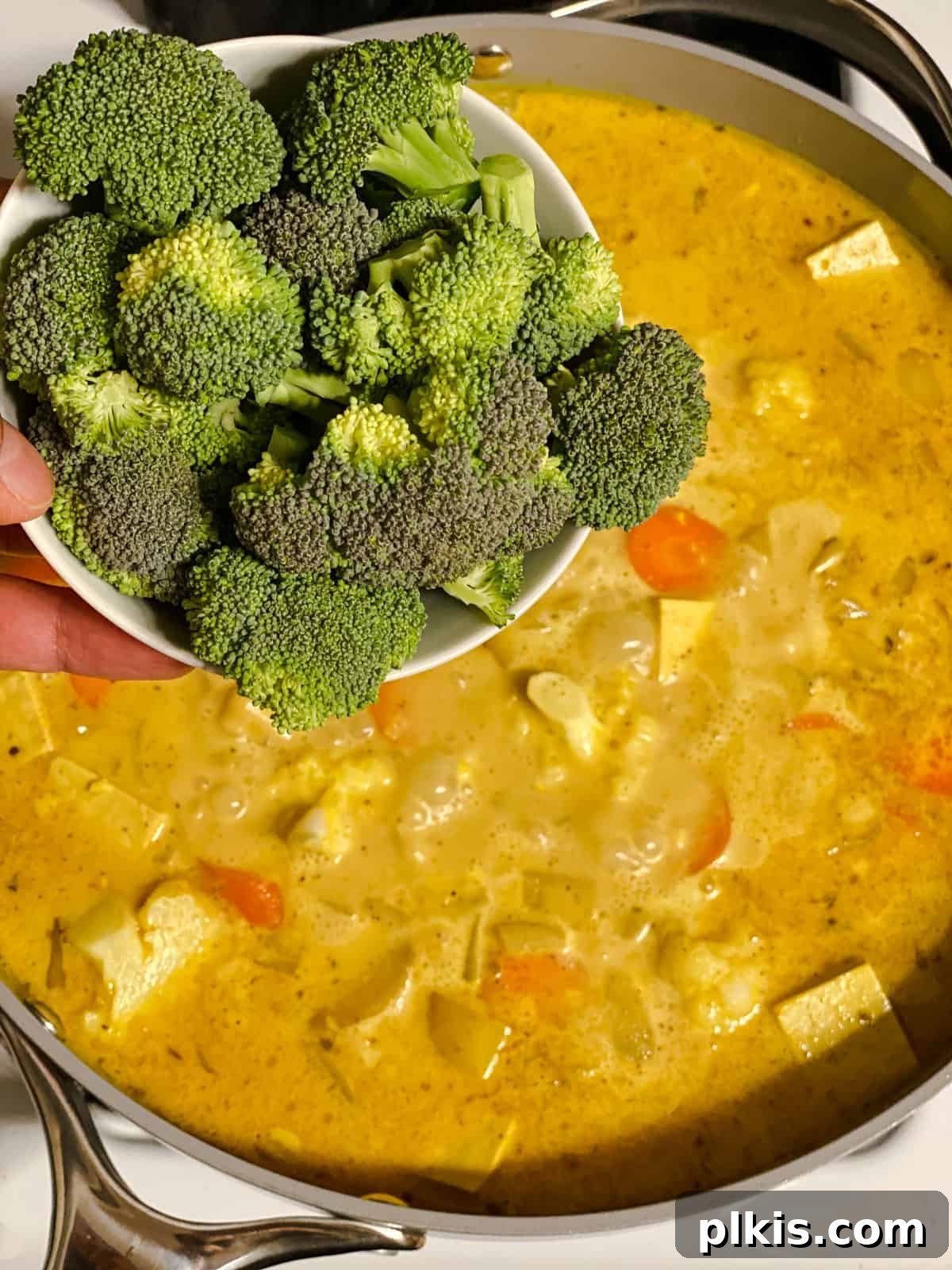 process shot of adding broccoli to pan