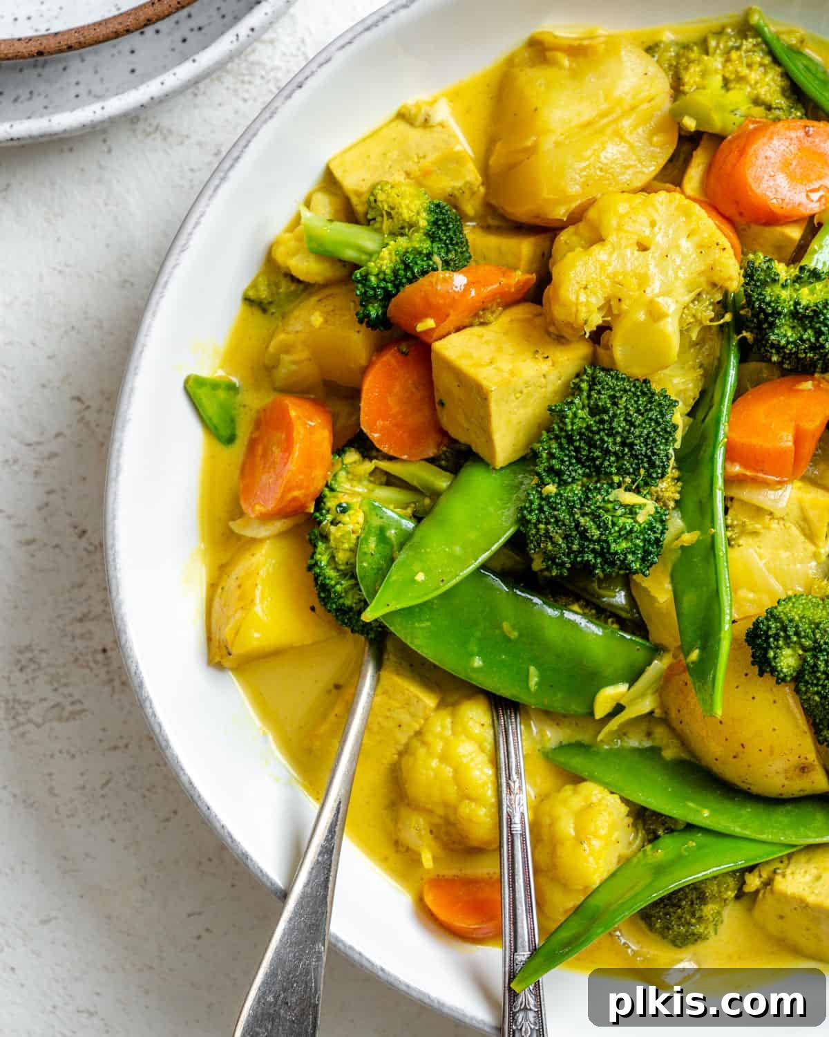 completed Easy Tofu Vegetable Coconut Curry in a bowl against a white background