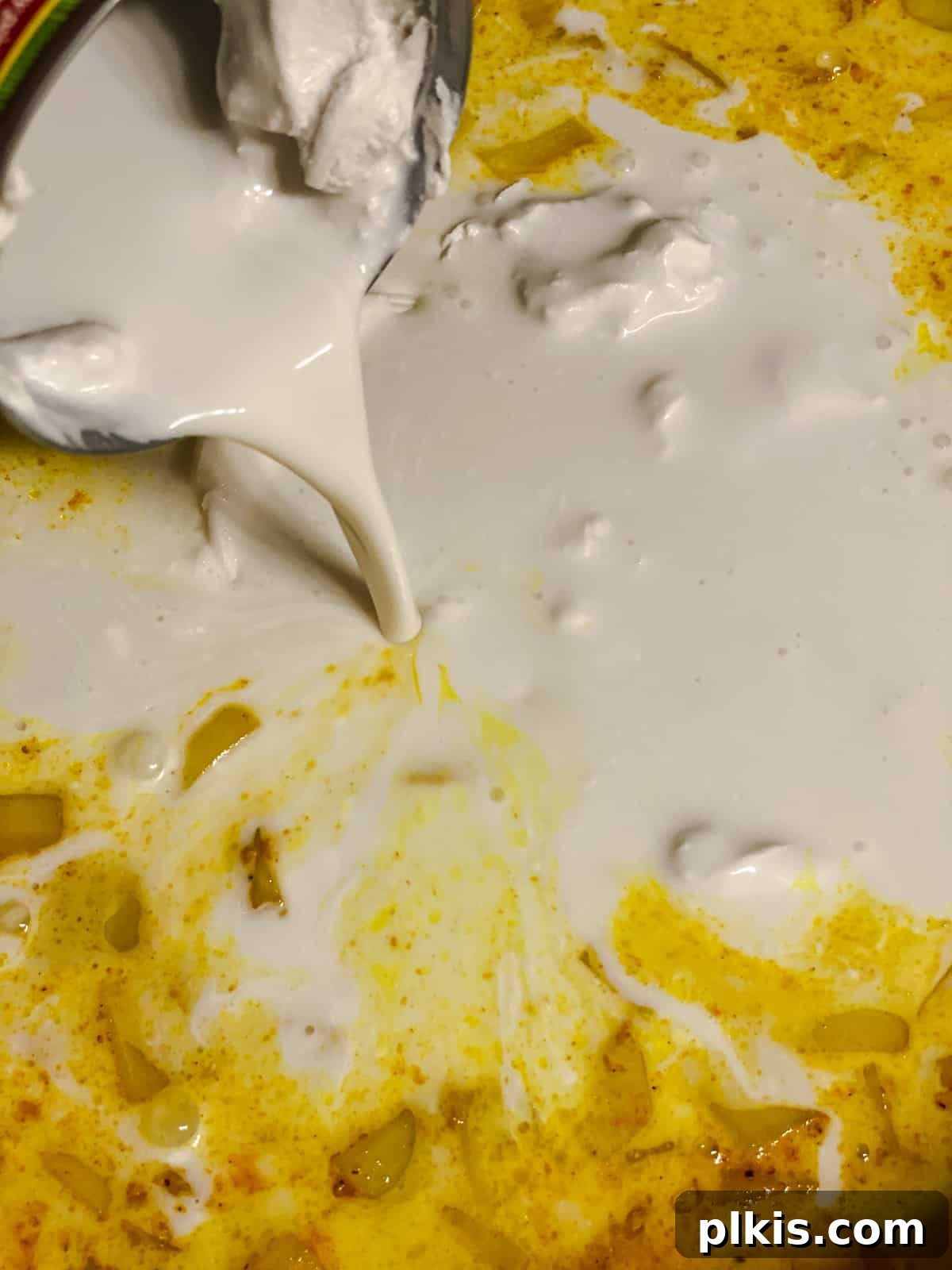 process shot of adding coconut milk to pan