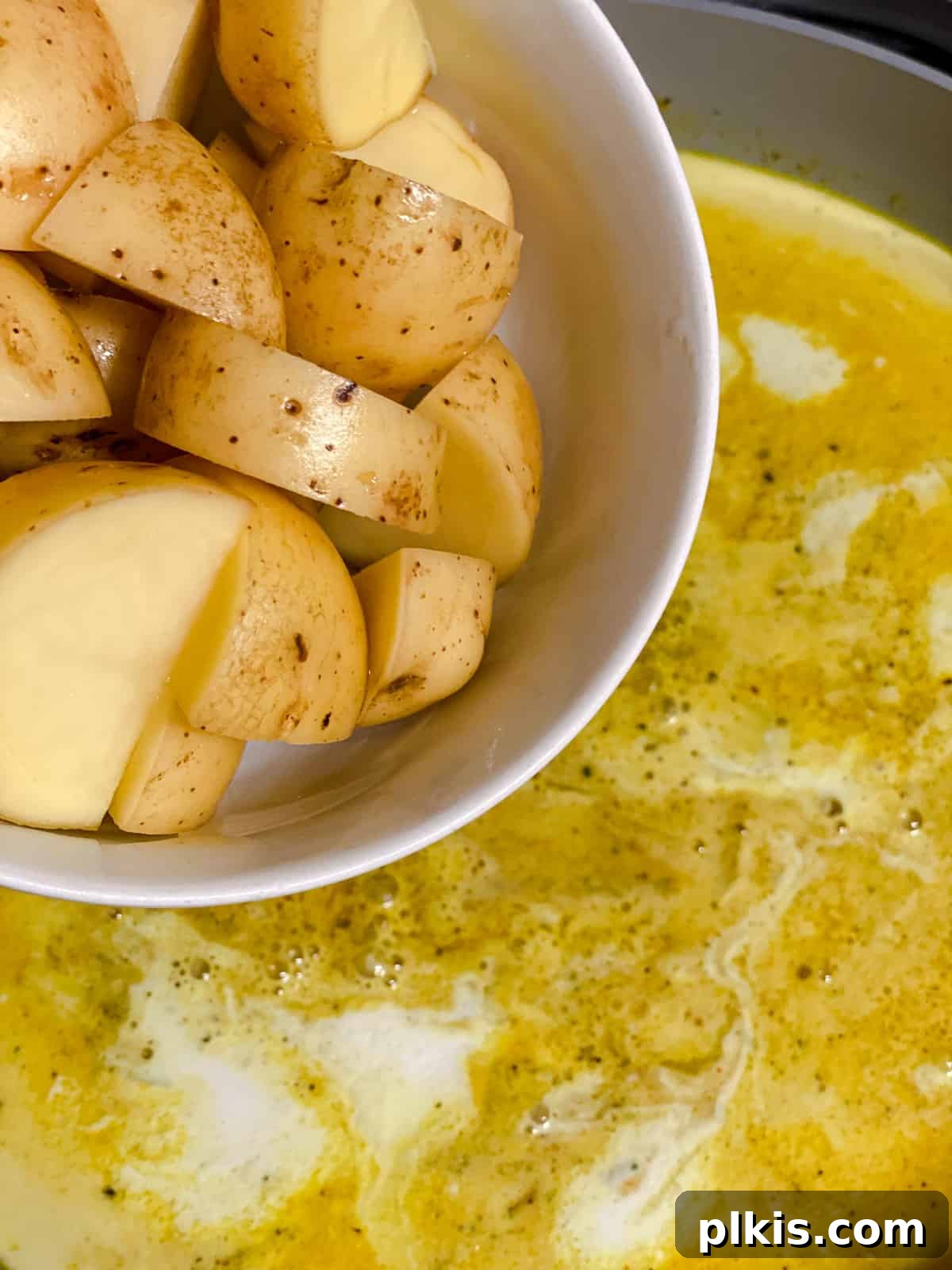 process shot of adding potatoes to pan