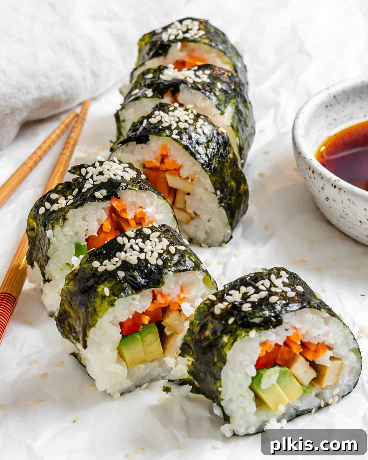 Plant-Powered Sushi Rolls 2 completed Vegan Sushi Rolls with Crispy Tofu spread out along a white surface