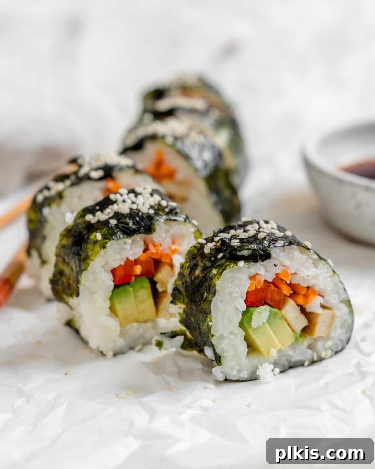 Plant-Powered Sushi Rolls 15 completed Vegan Sushi Rolls with Crispy Tofu spread out along a white surface