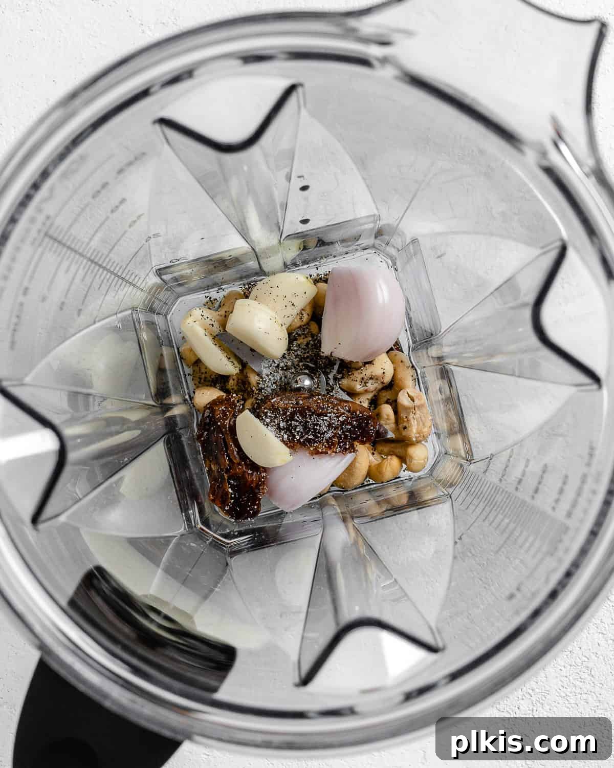 Process shot of Creamy Vegan Garlic Sauce ingredients being blended in a high-speed blender, showing initial mixing.