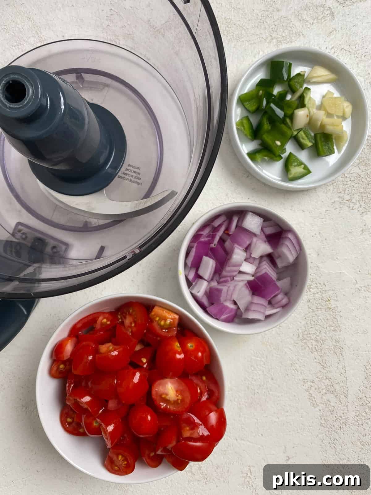 Blender Magic: 5-Minute Restaurant Salsa 4 Coarsely chopped fresh tomatoes, onion, garlic, and jalapeño arranged on a white cutting board, ready for blending.