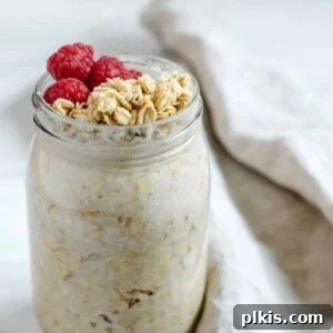 completed jar of coconut overnight oats with granola and fruit topping against a white background