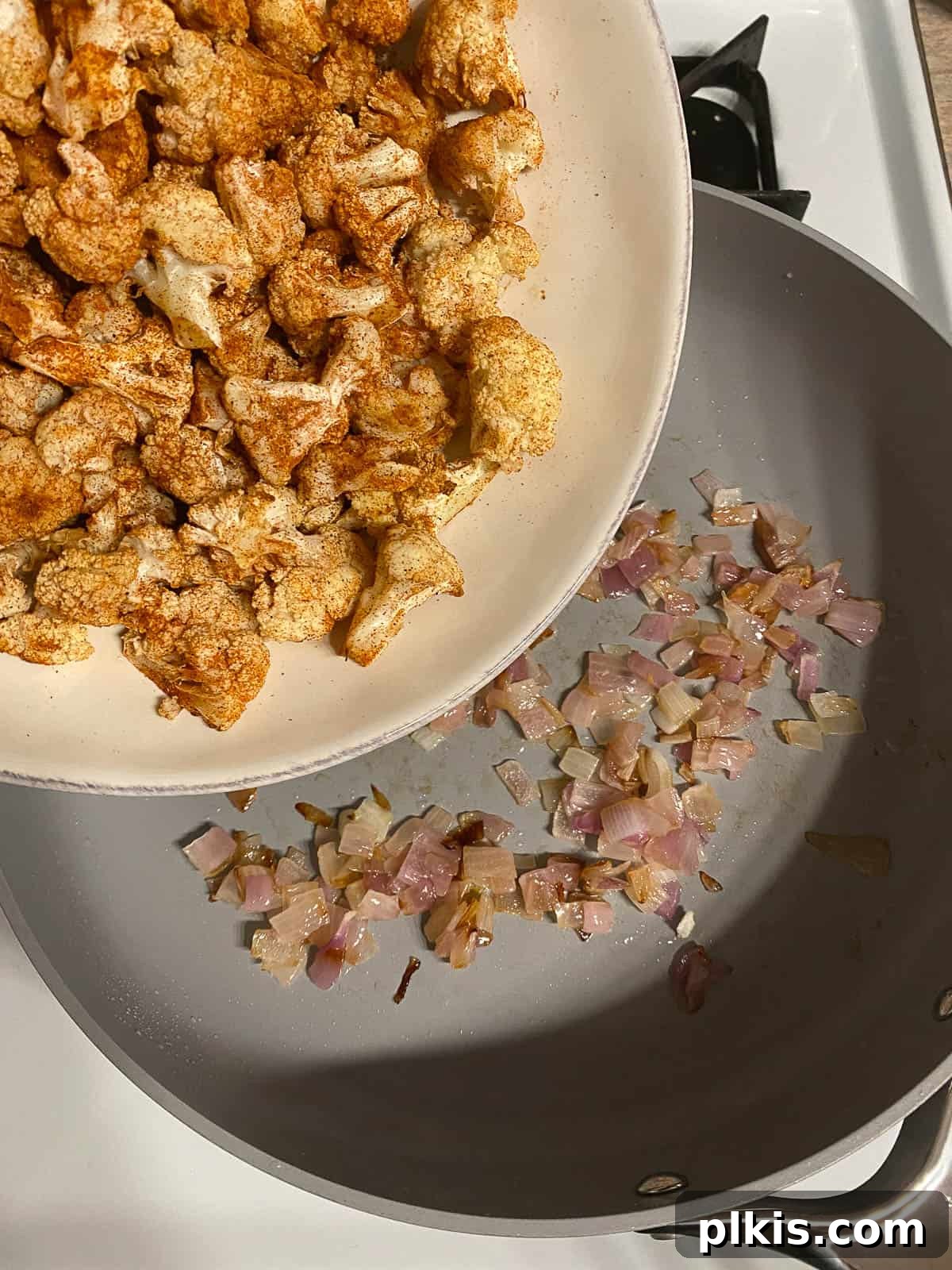 Roasted Cauliflower Tacos 9 Spiced cauliflower being added to the pan with sautéed onions, ready to cook further and meld flavors.