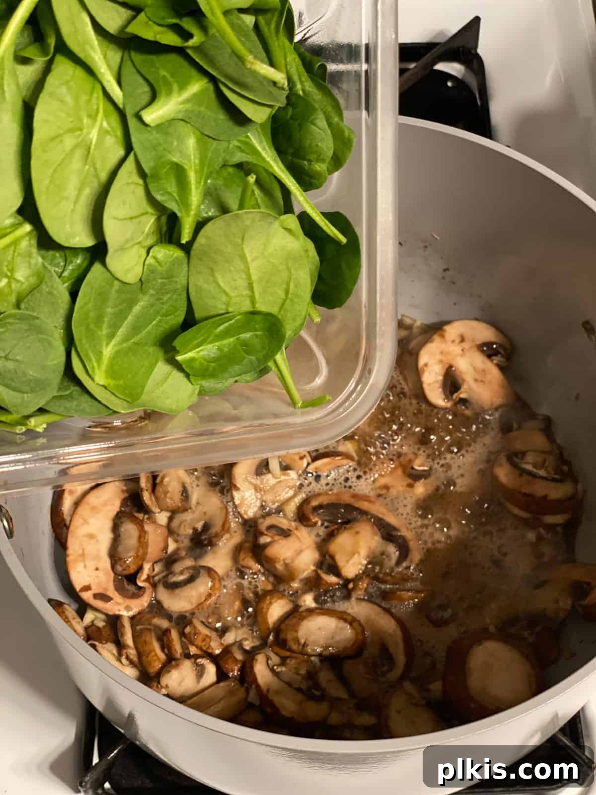 Savory Vegan Spinach Mushroom Pockets 4 Process shot of adding spinach to pan.