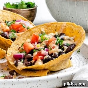 completed Crunchy Taco Cups with Black Beans plated on a white speckled plate