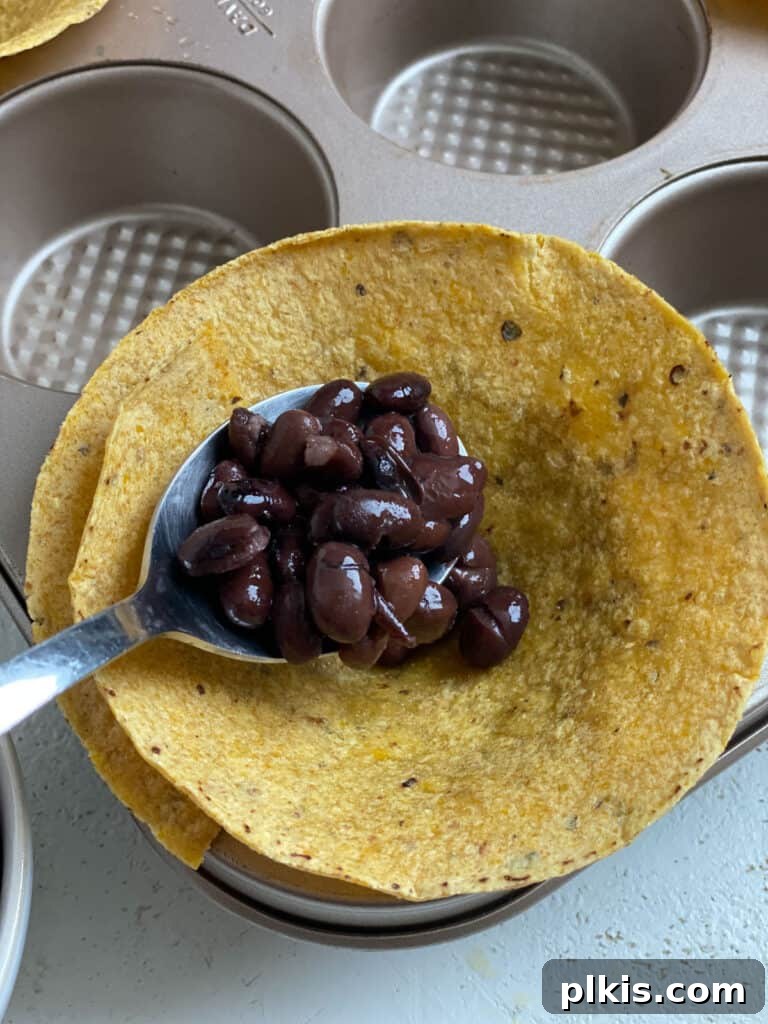 Zesty Black Bean Crunch Cups 6 process shot of adding black beans to tortillas