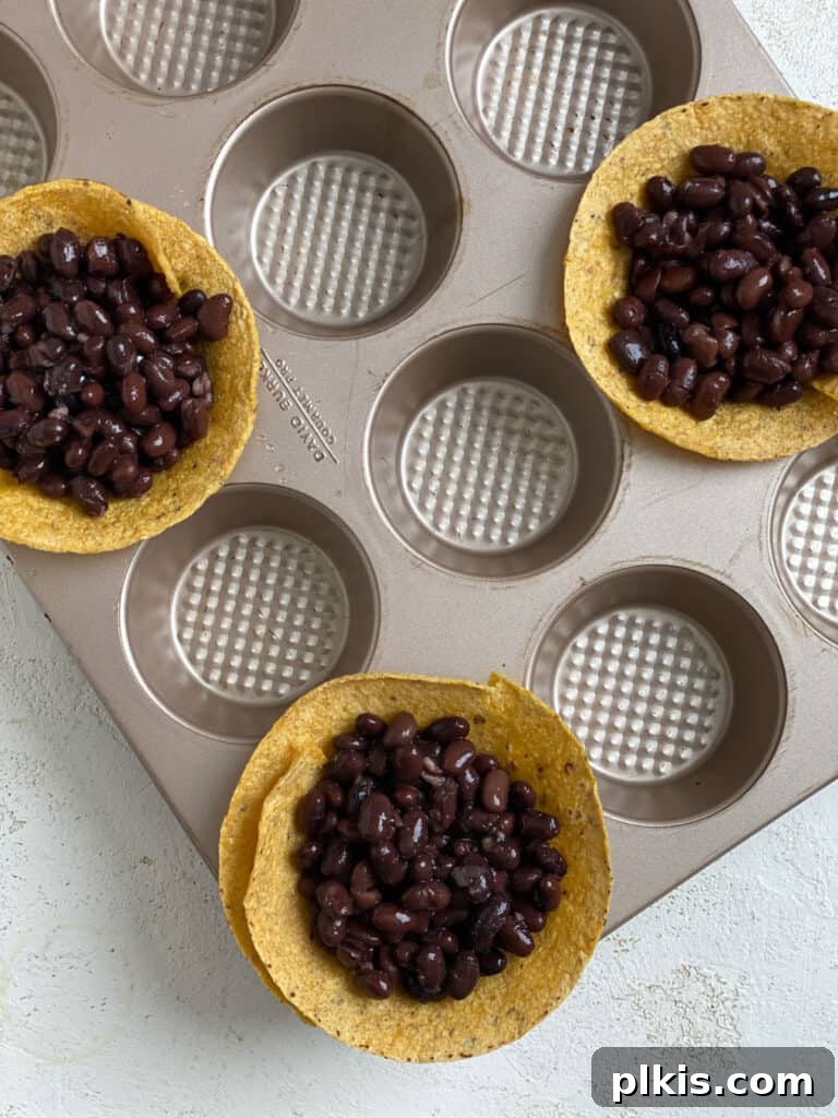 Zesty Black Bean Crunch Cups 7 process shot of adding black beans to tortillas