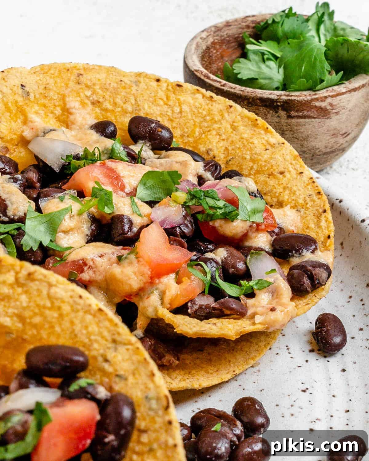 Zesty Black Bean Crunch Cups 10 completed Crunchy Taco Cups with Black Beans plated on a white speckled plate